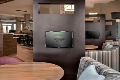 a restaurant with a tv on a wall at Courtyard by Marriott Schenectady at Mohawk Harbor in Schenectady