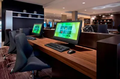 a desk with two computer monitors and a keyboard and mouse at Courtyard by Marriott Schenectady at Mohawk Harbor in Schenectady