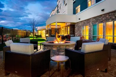 a patio with a fire pit and chairs and a building at Courtyard by Marriott Schenectady at Mohawk Harbor in Schenectady