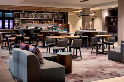 a restaurant with tables and chairs and a bar at Courtyard by Marriott Schenectady at Mohawk Harbor in Schenectady