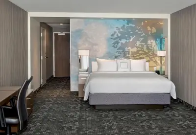 a bedroom with a bed and a painting on the wall at Courtyard by Marriott Schenectady at Mohawk Harbor in Schenectady