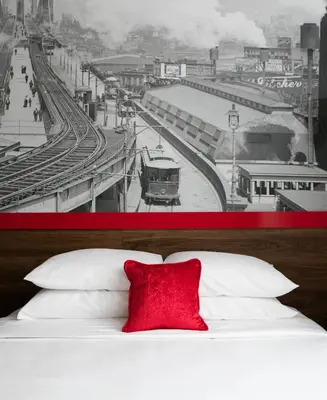 a black and white photo of a train station with a red pillow at Hotel 1080 in Brooklyn