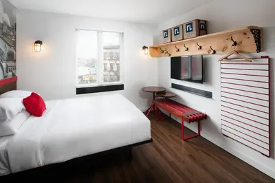 a bedroom with a white bed and a red bench at Hotel 1080 in Brooklyn