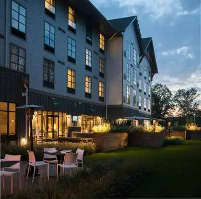an exterior view of a building with tables and chairs at Hotel Zero Degrees Danbury in Danbury