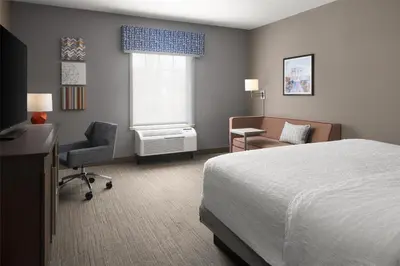 a bedroom with a bed and a desk and a chair at Hampton Inn & Suites Yonkers - Westchester in Yonkers
