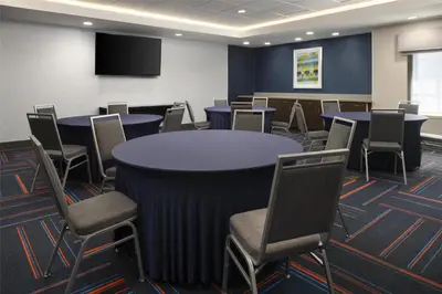 a conference room with tables and chairs and a screen at Hampton Inn & Suites Yonkers - Westchester in Yonkers
