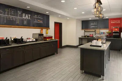 a restaurant kitchen with black cabinets and a counter at Hampton Inn & Suites Yonkers - Westchester in Yonkers