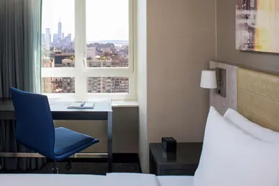 a hotel room with a bed and a desk and a window at Doubletree By Hilton New York Times Square West in New York