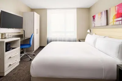 a hotel room with a large white bed and a desk at Doubletree By Hilton New York Times Square West in New York