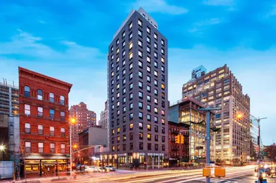 a tall building on a city street at night at Four Points by Sheraton Manhattan Midtown West in New York