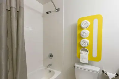a bathroom with a yellow number one sign above the toilet at Feather Factory Hotel in Queens