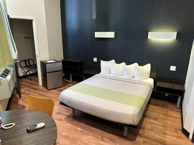 a hotel room with a bed and a table at Feather Factory Hotel in Queens