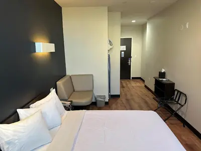 a hotel room with a bed and a chair at Feather Factory Hotel in Queens