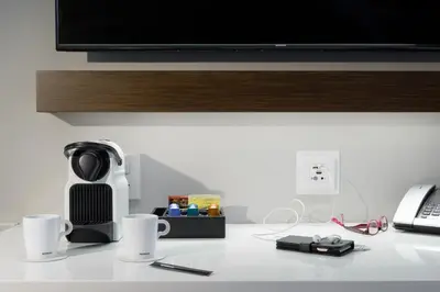 a counter with a coffee maker and cups on it at LUMA Hotel - Times Square in New York