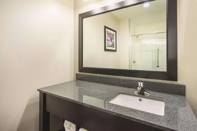 a bathroom with a sink and a mirror at La Quinta Inn & Suites by Wyndham Clifton Park Saratoga Area 1749 Route 9 in Clifton Park