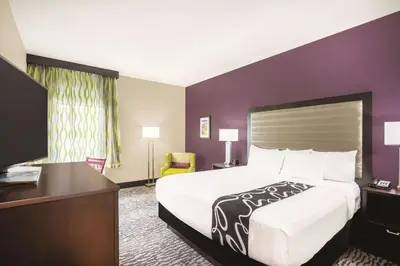 a hotel room with a large bed and a desk at La Quinta Inn & Suites by Wyndham Clifton Park Saratoga Area 1749 Route 9 in Clifton Park