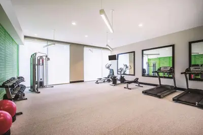 a gym with treadmills and ellipticals in a room at La Quinta Inn & Suites by Wyndham Clifton Park Saratoga Area 1749 Route 9 in Clifton Park