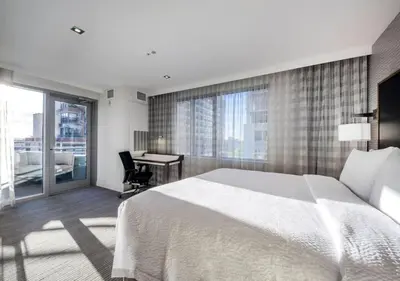 a bedroom with a large bed and a desk with a window at Residence Inn by Marriott Jersey City in Jersey City