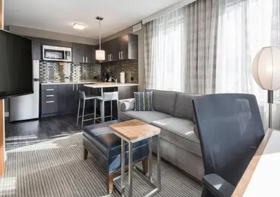 a living room with a couch and a kitchen at Residence Inn by Marriott Jersey City in Jersey City