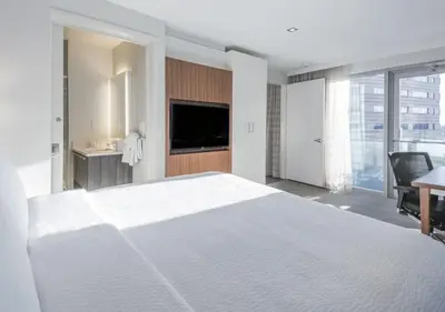 a white bedroom with a large bed and a desk at Residence Inn by Marriott Jersey City in Jersey City