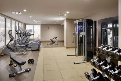 a gym with several treadmills and machines in a room at Hilton Garden Inn Roslyn in Roslyn