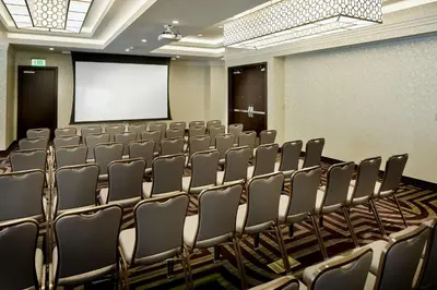 a conference room with chairs and a projection screen at Hilton Garden Inn Roslyn in Roslyn