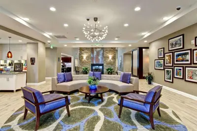 a living room with a couch and a table and chairs at Homewood Suites By Hilton Clifton Park in Clifton Park