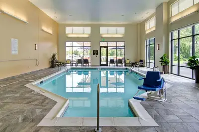a large swimming pool with a blue chair in a room at Homewood Suites By Hilton Clifton Park in Clifton Park