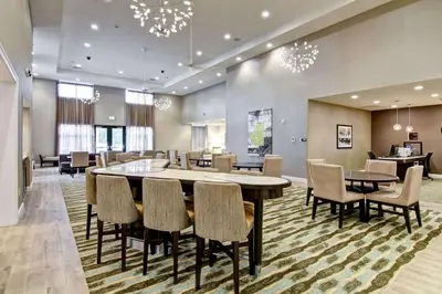 a dining room with a large table and chairs at Homewood Suites By Hilton Clifton Park in Clifton Park