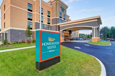 a sign for a honeymoon suites hotel in front of a building at Homewood Suites By Hilton Clifton Park in Clifton Park