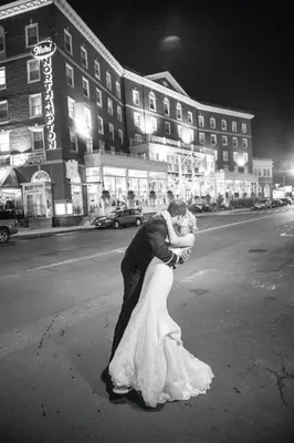 a bride and groom kissing in the middle of the street at The Hotel Northampton in Northampton