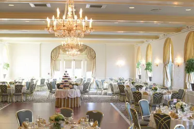 a banquet hall with tables and chairs and a chandelier at The Hotel Northampton in Northampton