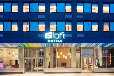 a blue building with an edit moths sign on it at Aloft Long Island City-Manhattan View in Queens