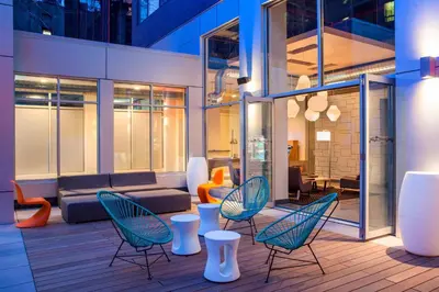 a patio with chairs and a couch in a building at Aloft Long Island City-Manhattan View in Queens