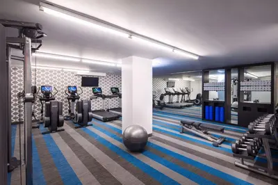 a gym with several treadmills and cardio machines at Aloft Long Island City-Manhattan View in Queens