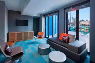 a living room with a couch and a view of the city at Aloft Long Island City-Manhattan View in Queens