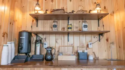 a room with wooden walls with shelves and a appliance at Hunter Lodge, a Bluebird by Lark in Hunter