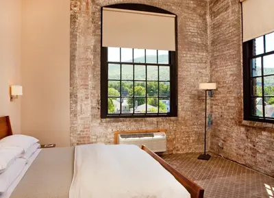 a bedroom with a bed and a brick wall at The Roundhouse in Beacon