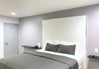 a bedroom with a large bed with a large headboard at Ramsey Inn & Suites in Ramsey