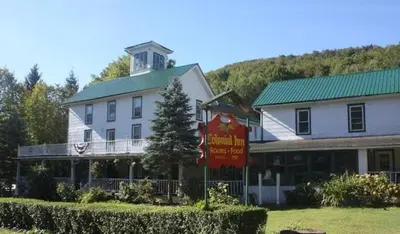 a large white building with a sign in front of it at Colonial Inn in Pine Hill