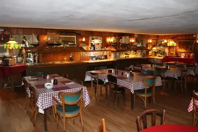 a restaurant with tables and chairs and a kitchen at Colonial Inn in Pine Hill
