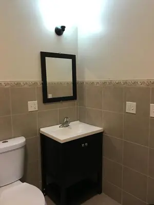 a bathroom with a sink and a toilet and a mirror at Waterbury Big Apple Motel in Waterbury