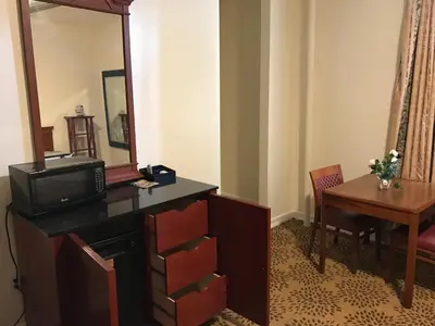 a room with a tv and a table and a mirror at Waterbury Big Apple Motel in Waterbury