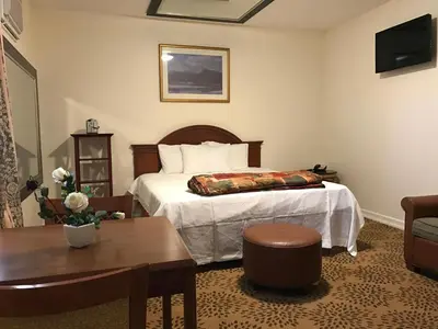 a hotel room with a bed and a table at Waterbury Big Apple Motel in Waterbury