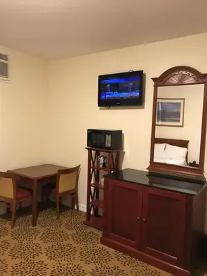 a room with a desk and a mirror and a table at Waterbury Big Apple Motel in Waterbury
