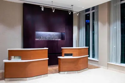 a lobby with two counters and a purple wall at Courtyard by Marriott New York Queens/Fresh Meadows in Queens
