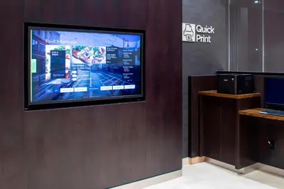 a flat screen tv on a wall in a store at Courtyard by Marriott New York Queens/Fresh Meadows in Queens