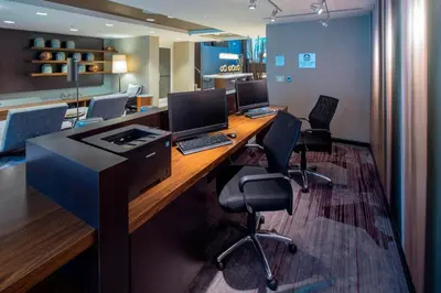 an office with a desk with two computers and chairs at Courtyard by Marriott New York Queens/Fresh Meadows in Queens