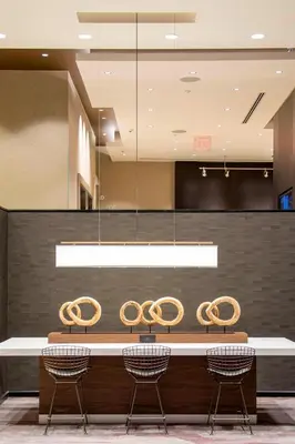 a lobby with a long table with chairs at Courtyard by Marriott New York Queens/Fresh Meadows in Queens