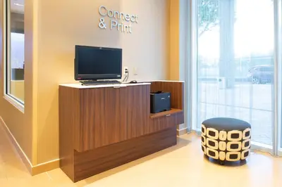a office with a computer on a counter and a stool at Fairfield Inn & Suites by Marriott New York Queens/Fresh Meadows in Queens